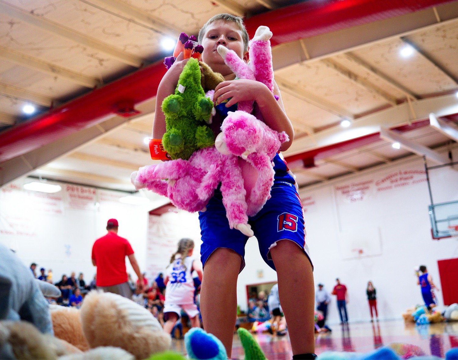 Hogan Webster helps gather stuffed animals following the girls game. Those attending could donate a stuffed toy in lieu of admission, to be donated to Toys for Tots by the Alba-Golden Youth Foundation.